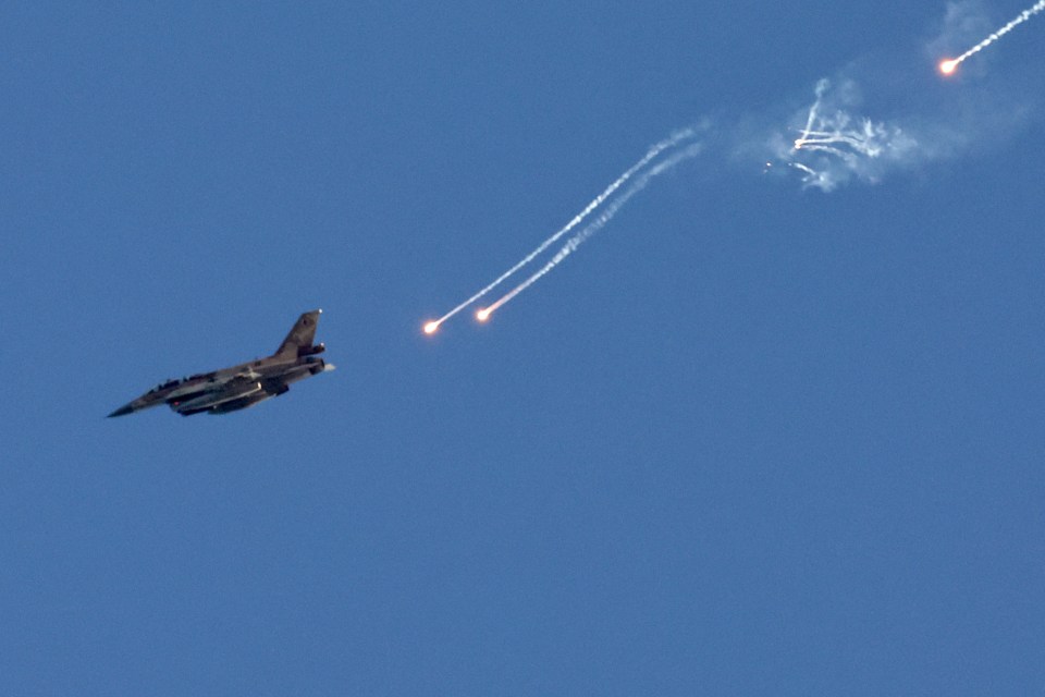 An Israeli fighter jet ejects flares over an area near the Lebanon-Israel border today