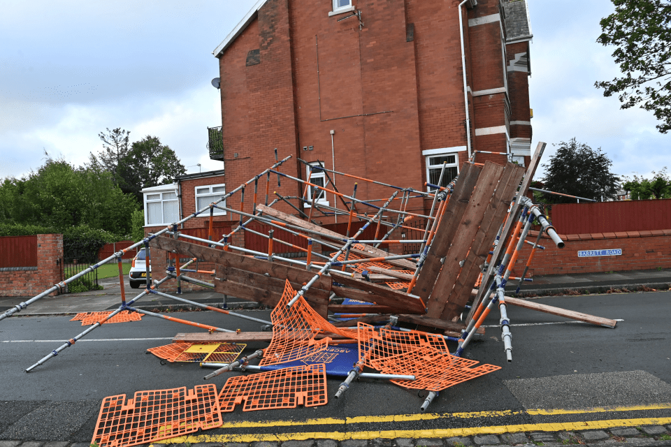 a scaffolding collapsed in front of a brick building with a sign on the wall that says shepherds lane