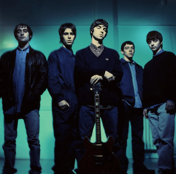 a group of men standing next to each other with one man holding a guitar