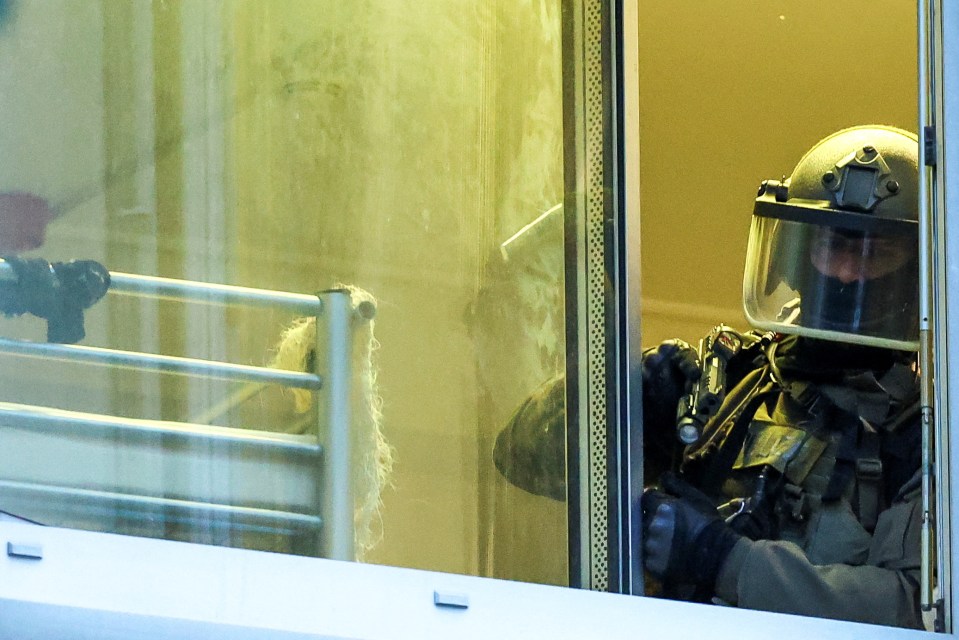 Special police forces officer looks out from a window after the horror incident