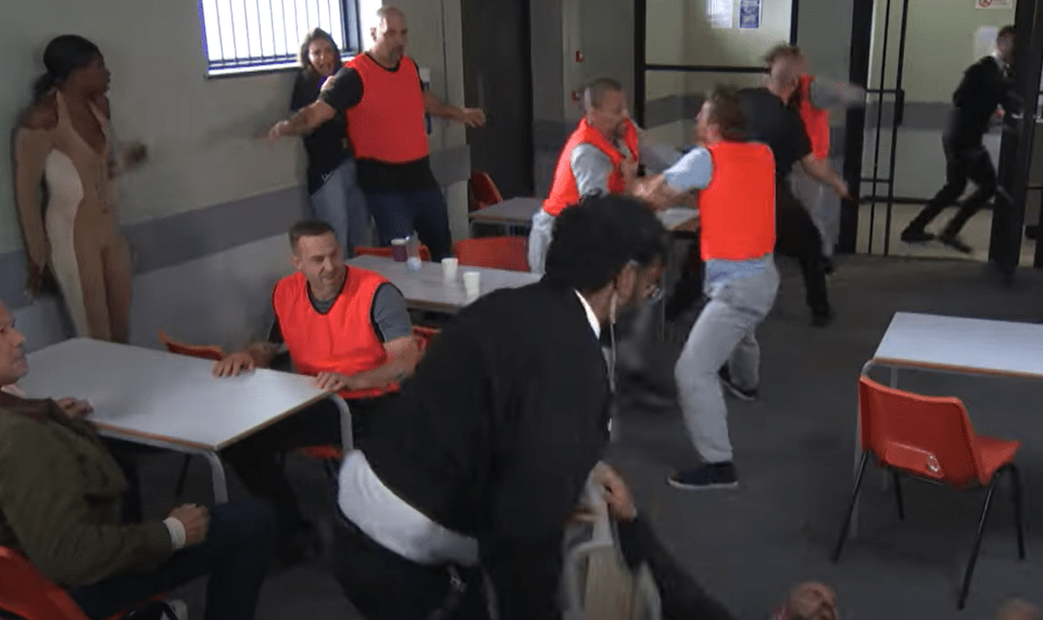 a group of people in orange vests are standing around tables