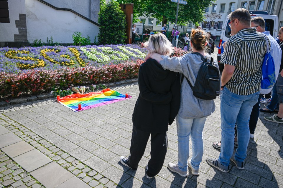 People in mourning standing close to the site of the deadly stabbings that left three dead