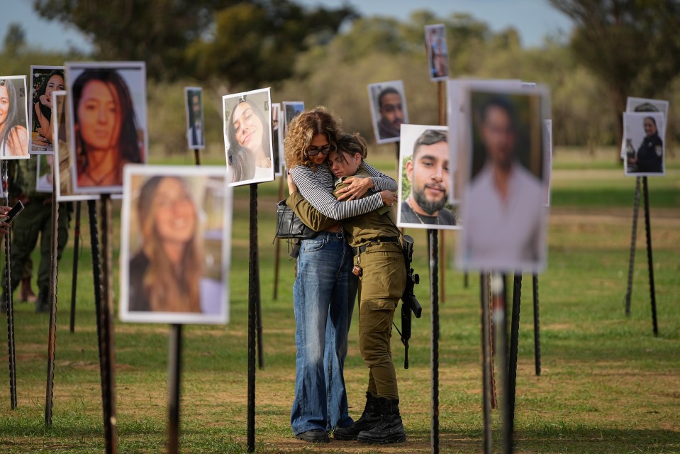 A woman embraces a soldier at the memorial site for those murdered at the music festival