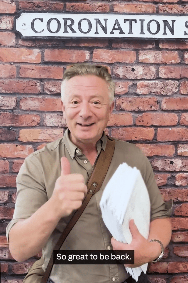 a man giving a thumbs up in front of a sign that says coronation street