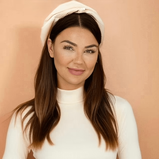 a woman wearing a white headband and a white turtleneck