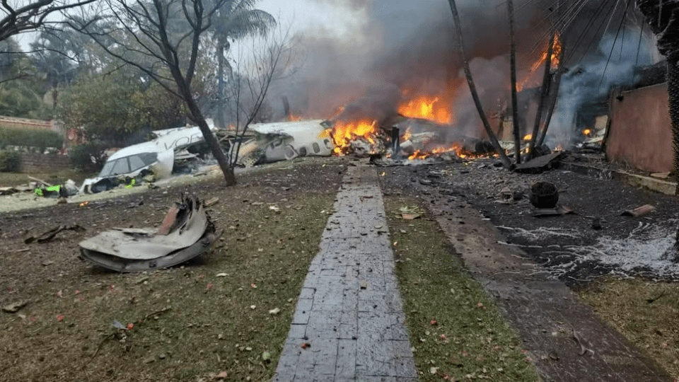 a plane that has crashed into a house with flames coming out of it