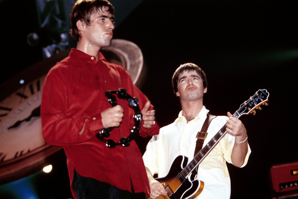 a man in a red shirt is holding a tambourine and a man in a yellow shirt is holding a guitar