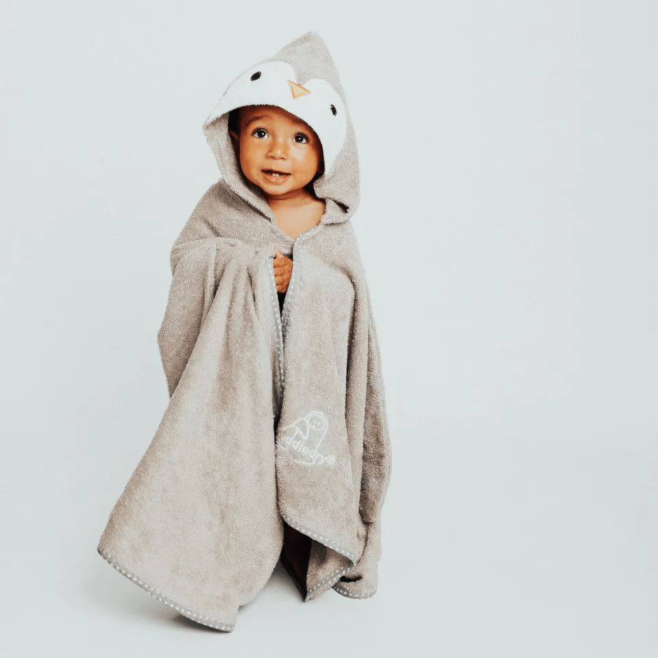 a baby wrapped in a hooded towel with a penguin on it