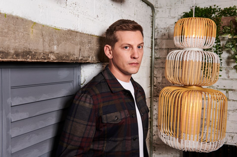 a man in a plaid shirt stands in front of a row of wicker lamps