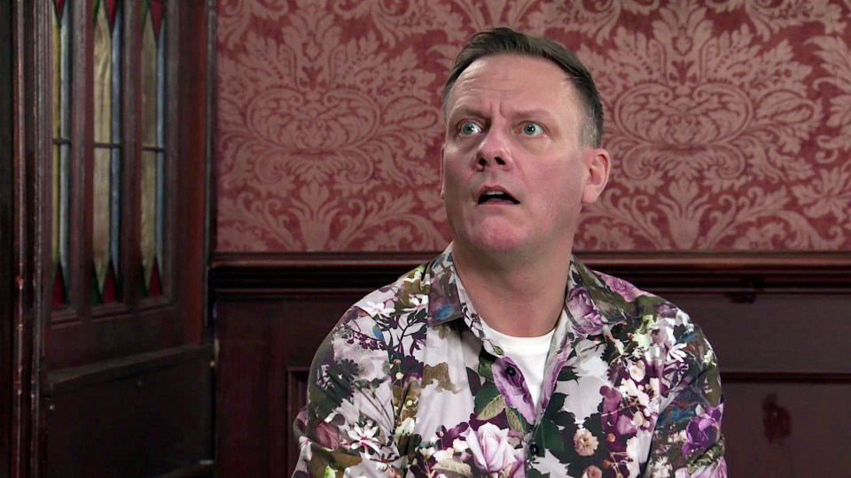 a man wearing a floral shirt is making a funny face