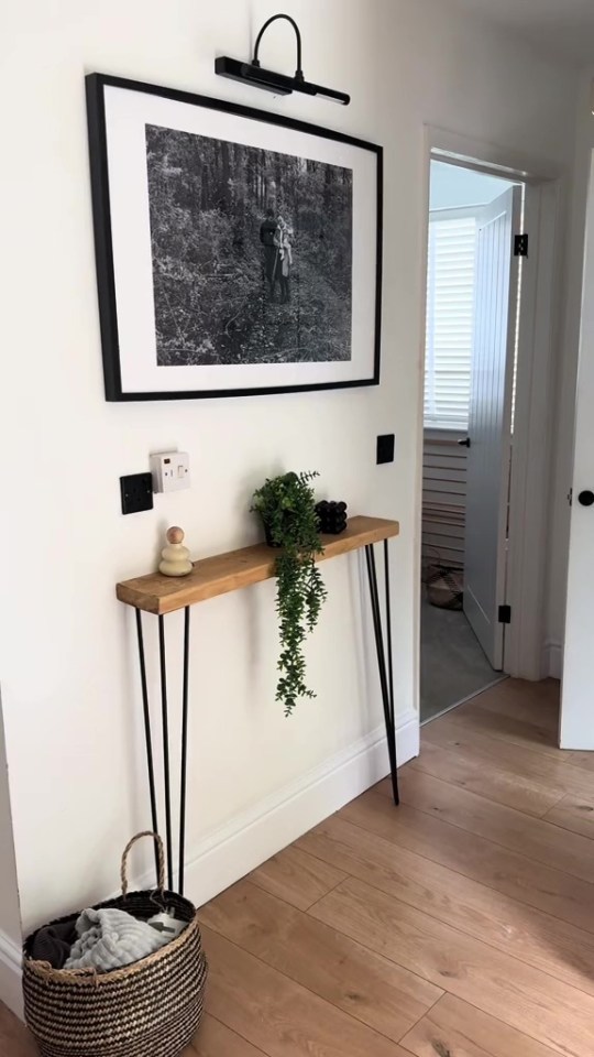 a black and white photo hangs above a wooden table