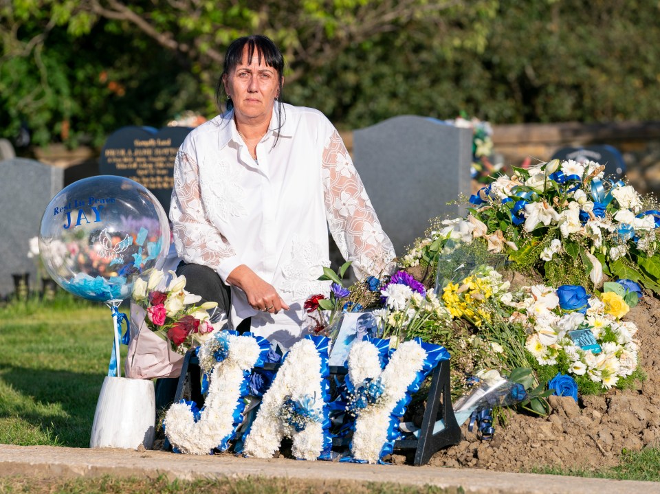 The grieving mum pictured beside Jay's grave in Accrington, Lancs