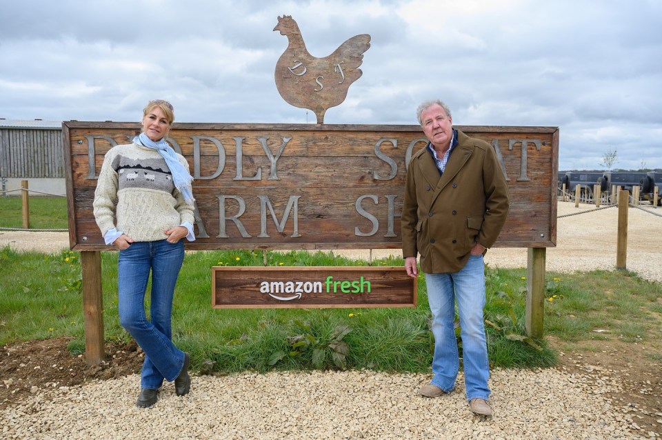 Jeremy is seen with his partner Lisa Hogan outside the farm's sign