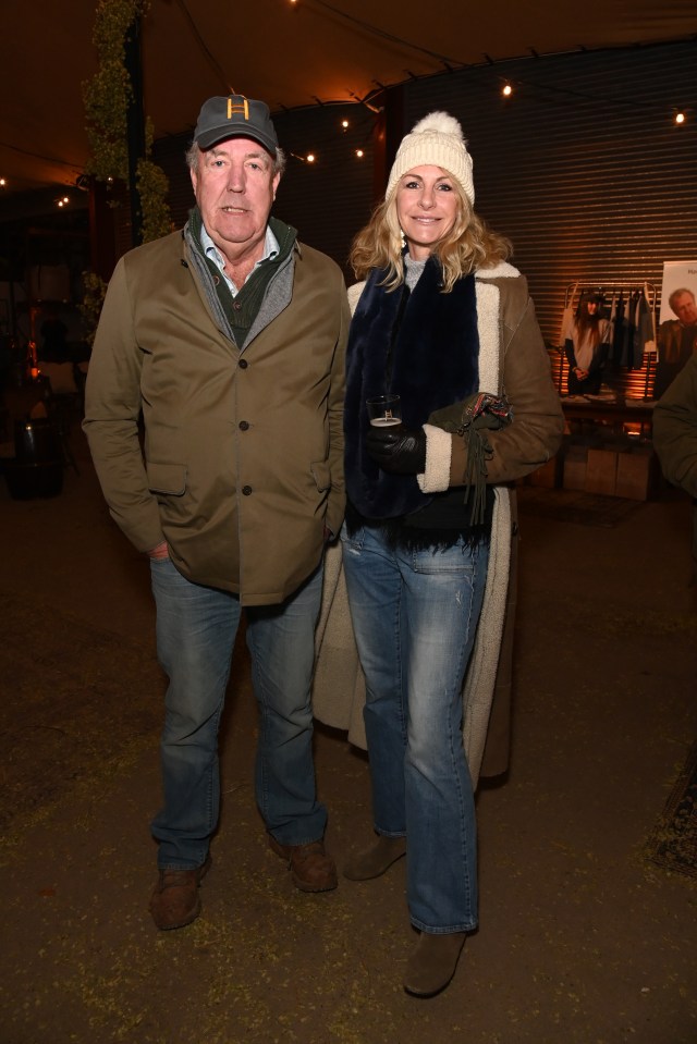 a man wearing a hat with the letter h on it stands next to a woman