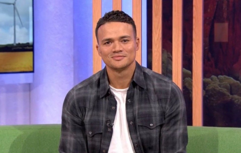 a man in a plaid shirt is sitting on a green couch