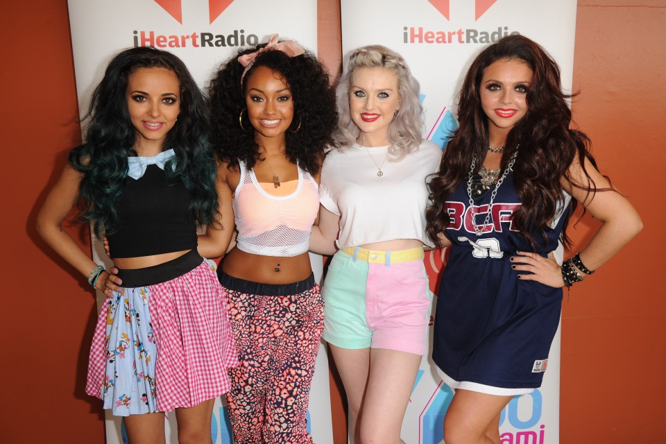 four girls are posing for a picture in front of a sign that says iheartradio