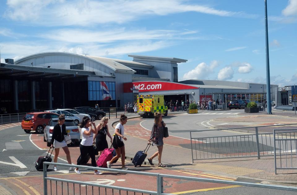 a group of people walking in front of a building that says jet2.com