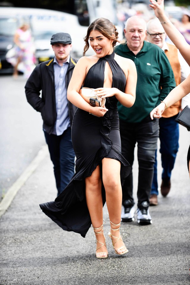 One woman in a show-stopping black dress beamed as she arrived for Haydock racing