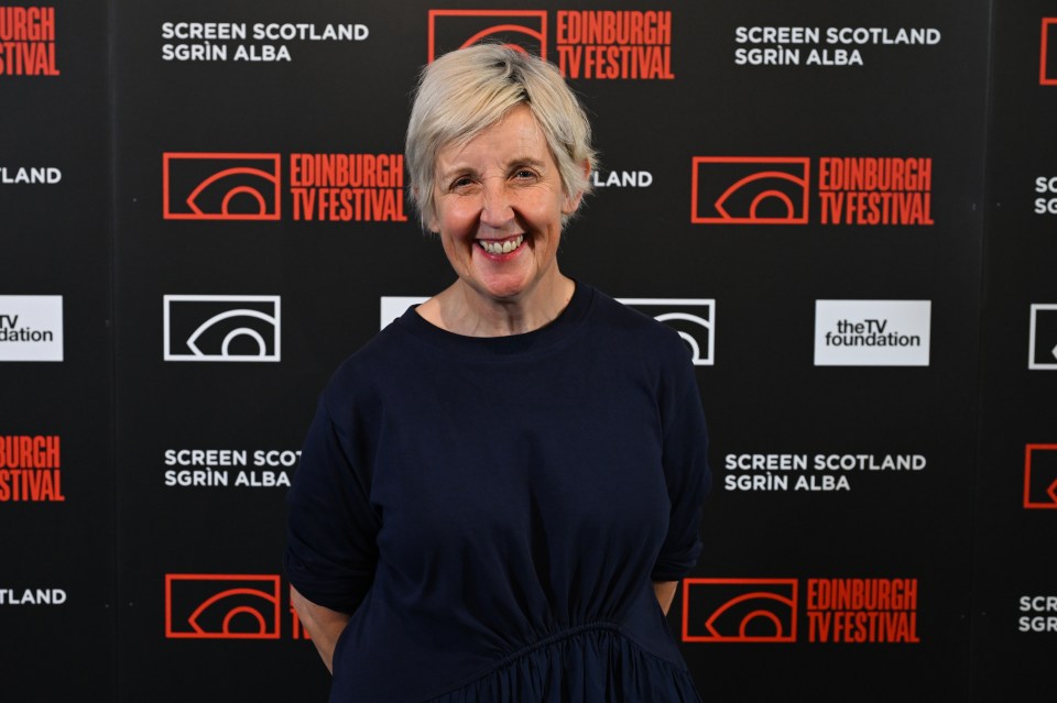 a woman stands in front of a wall that says edinburgh tv festival