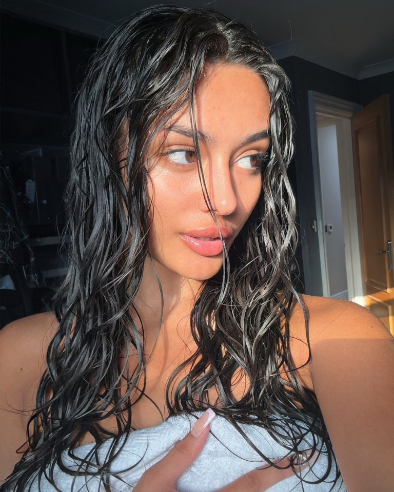 a woman with wet hair is wrapped in a white towel