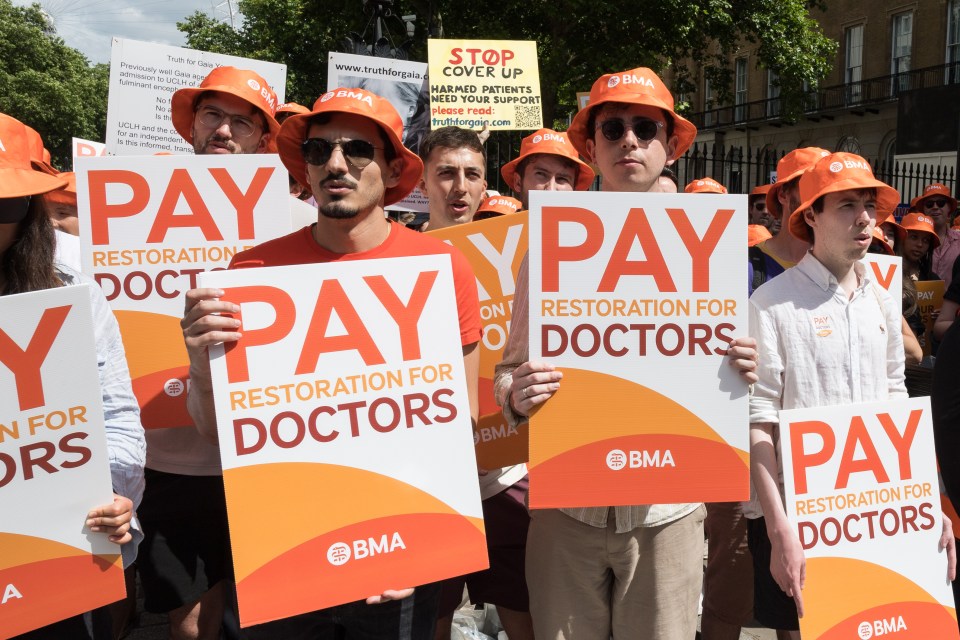 a group of people holding signs that say pay restoration for doctors