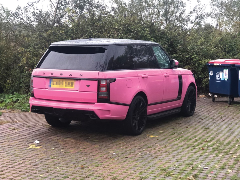 a pink range rover is parked in a parking lot