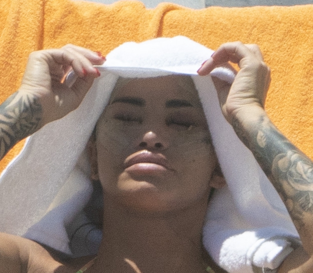 a woman with a tattoo on her arm is wrapped in a white towel