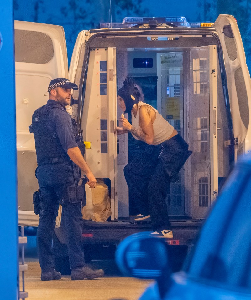 a police officer talks to a man in a white van