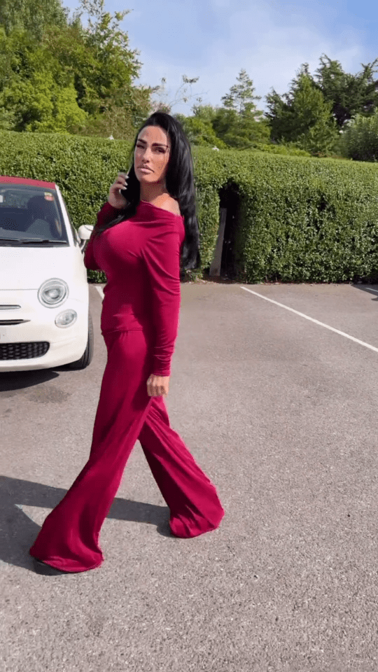 a woman in a red jumpsuit is walking in front of a white car