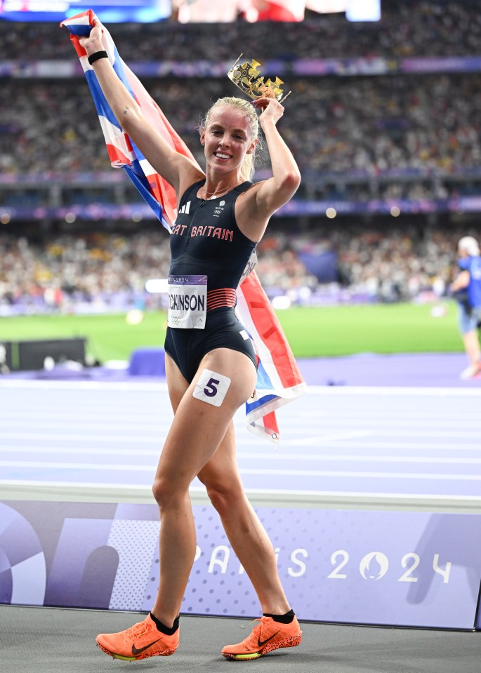 Keely Hodgkinson, a British Olympic athlete, celebrates her 800m victory in Paris, holding a gold crown and the British flag.