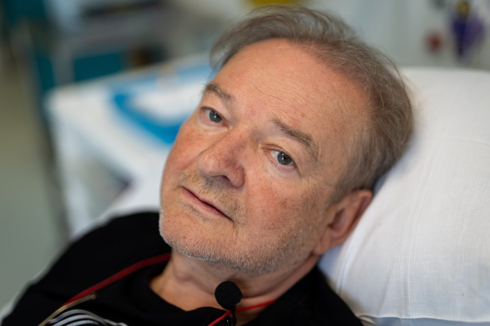 a man with a beard is laying in a hospital bed