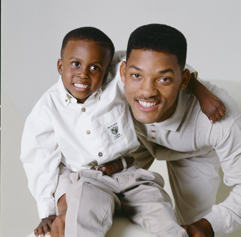 a man and a boy are posing for a picture and the boy is wearing a shirt that says raiders