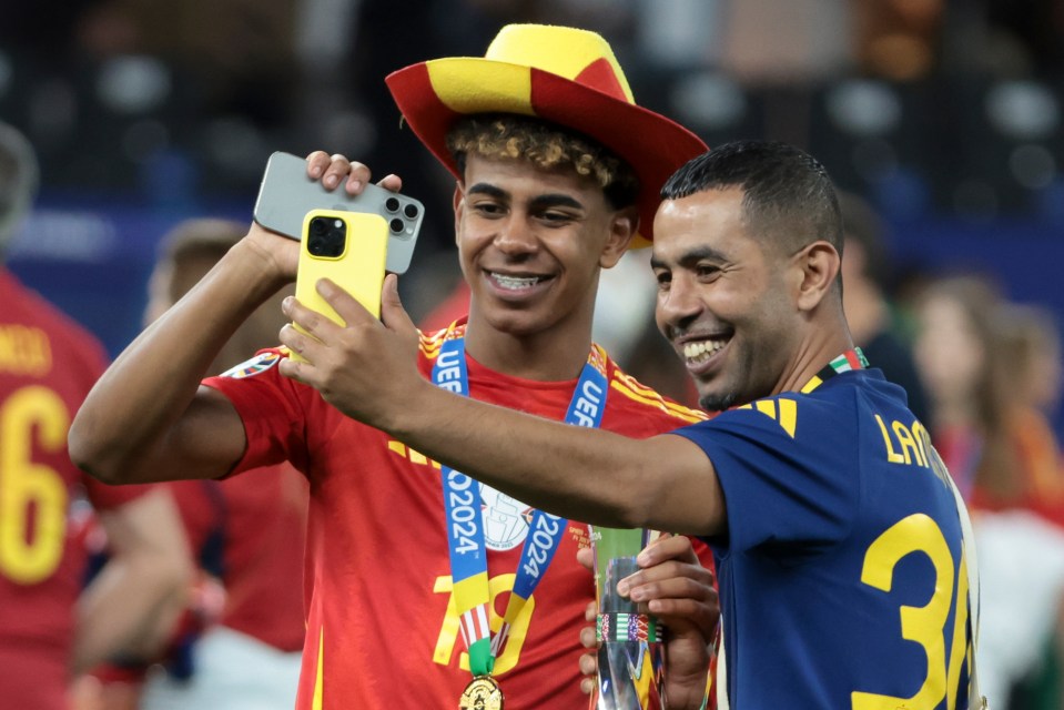 two soccer players taking a selfie with a uefa medal around their necks