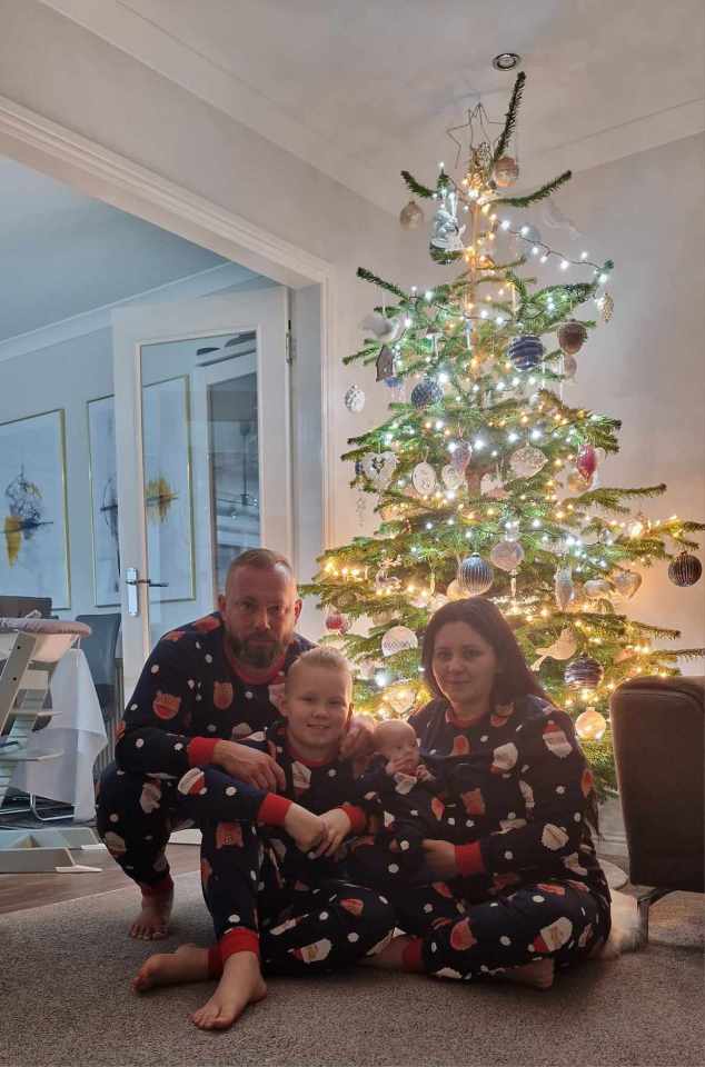 a family posing in front of a christmas tree