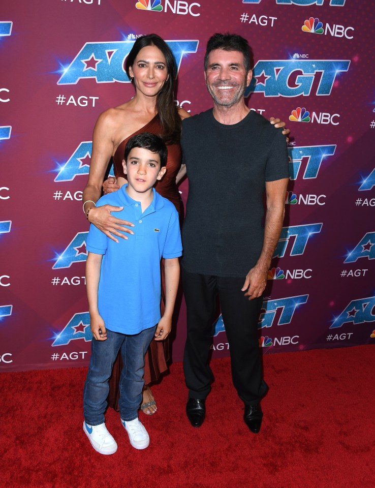 a man and woman standing on a red carpet in front of a sign that says agt