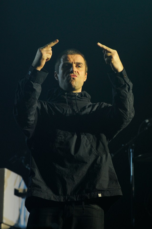 a man in a black jacket is making a funny face with his fingers