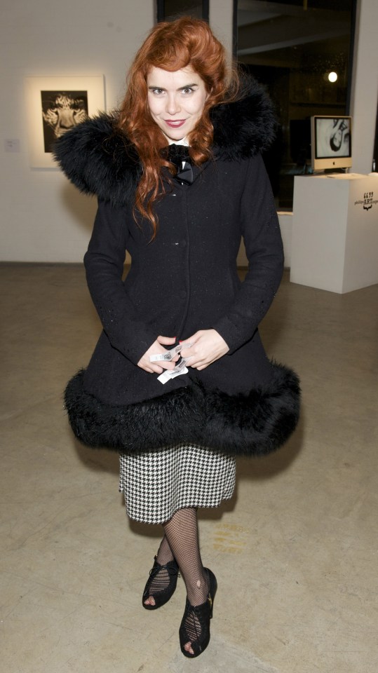 a woman wearing a black coat with a fur hood