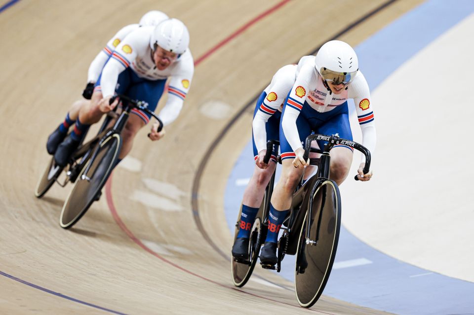 two cyclists are racing on a track and one has the word shell on his shirt