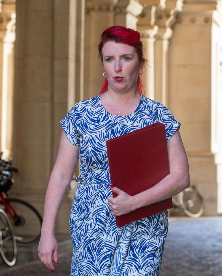 a woman in a blue and white dress is holding a red folder