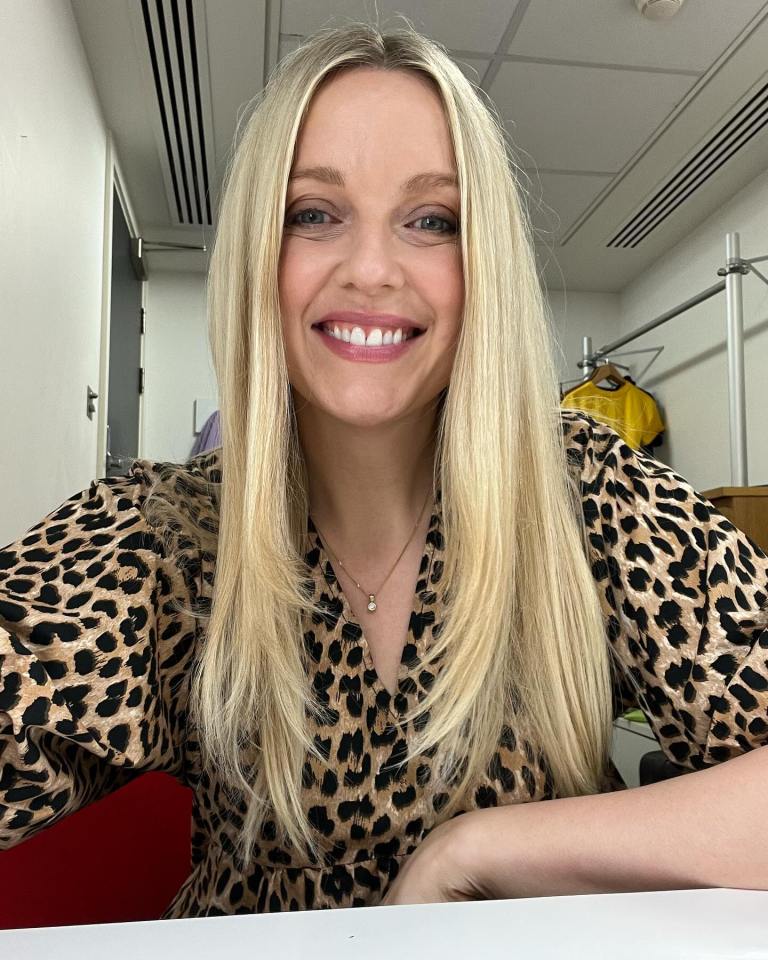 a woman wearing a leopard print shirt smiles for the camera