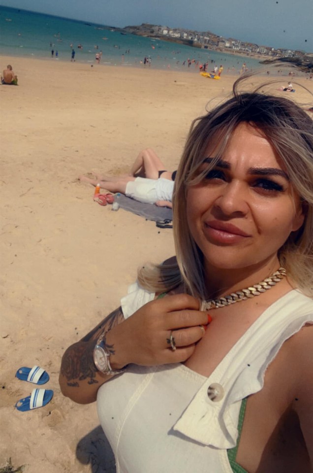 a woman taking a picture of herself on the beach