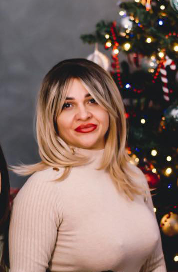 a woman is standing in front of a christmas tree .