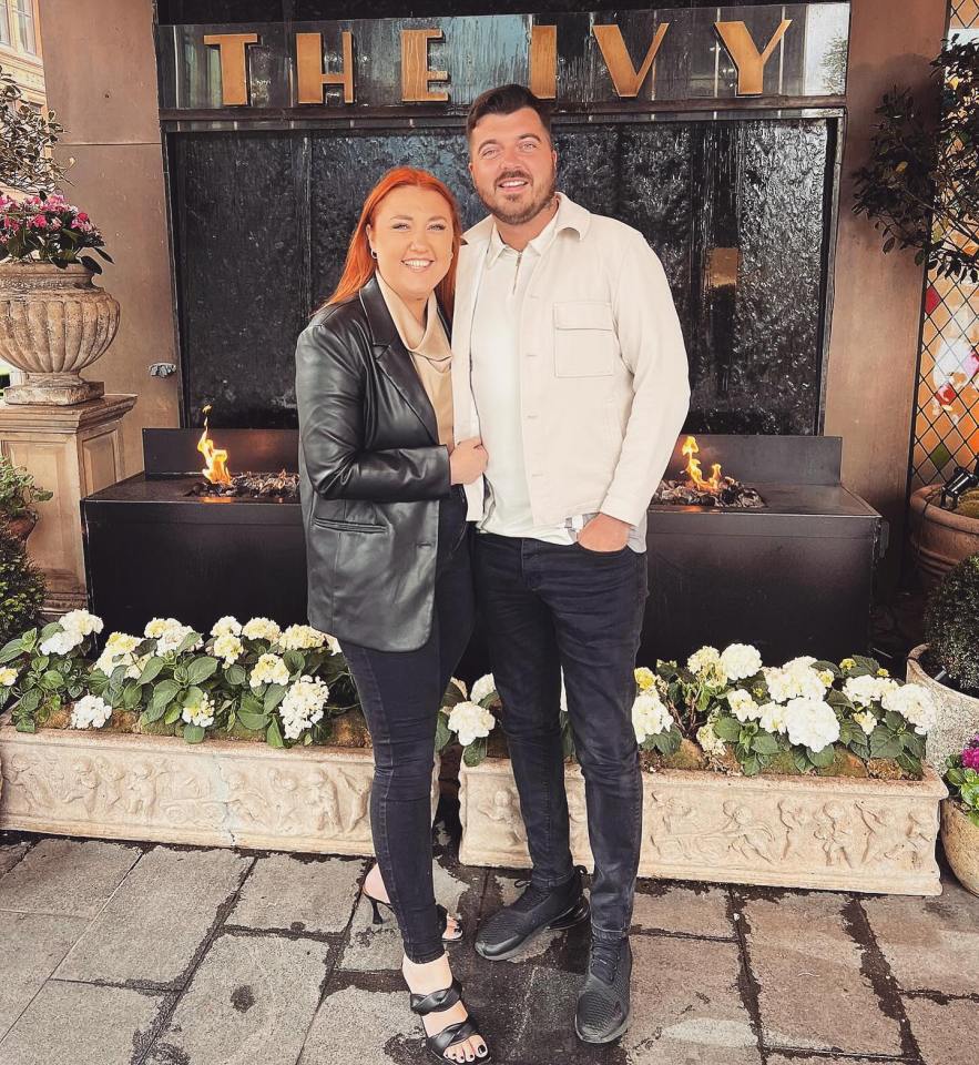 a man and woman standing in front of a sign that says the ivy