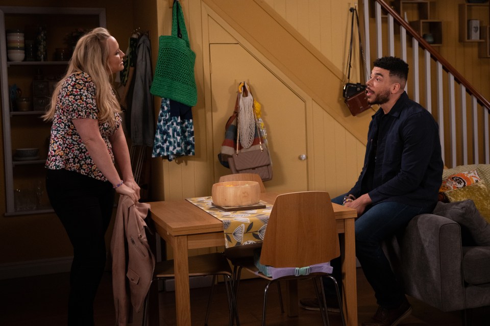 a man sitting at a table talking to a woman