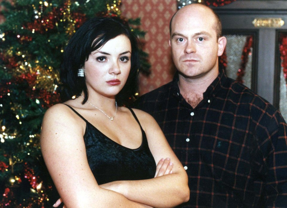 a man and a woman standing in front of a christmas tree