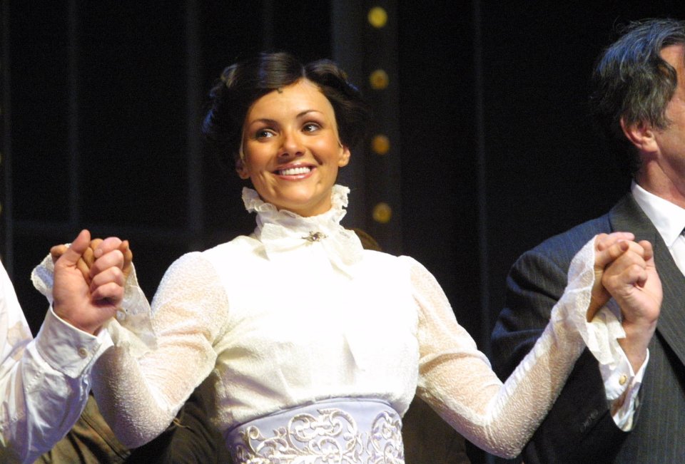 a woman in a white dress holds hands with a man in a suit