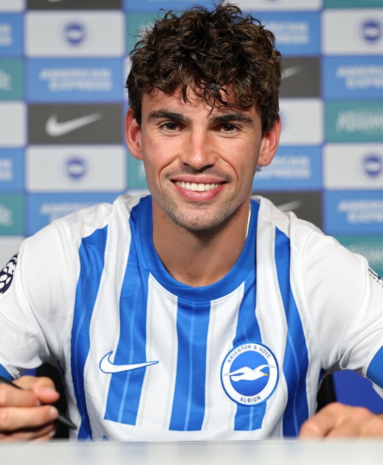 a man in a brighton and hove albion jersey smiles for the camera