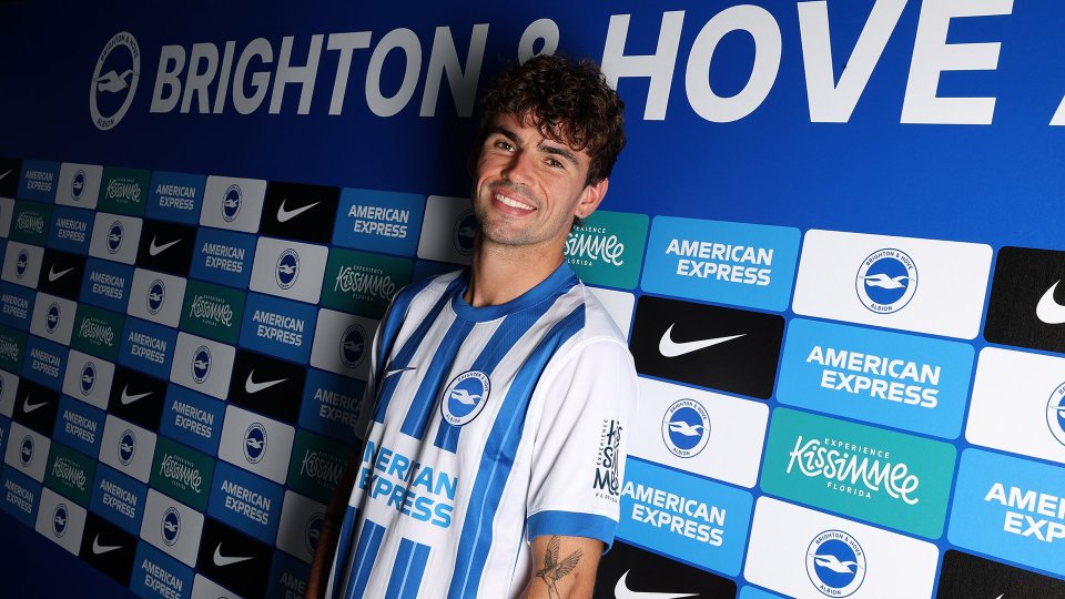 a man stands in front of a brighton & hove banner