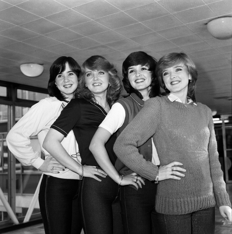 four women posing for a picture with their hands on their hips