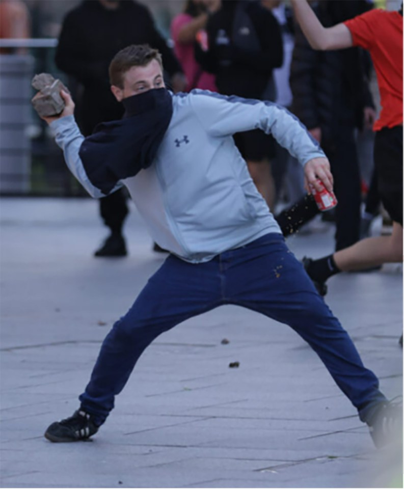 a man wearing a blue under armour sweatshirt is throwing a rock